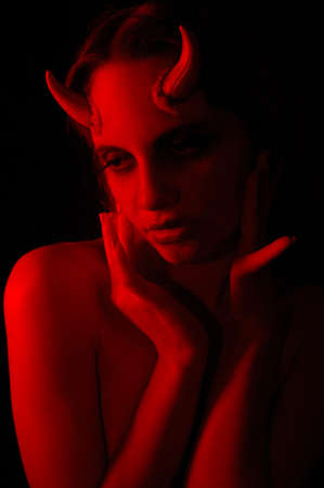 Photo of a Female demon with horns looking seductiveの写真素材
