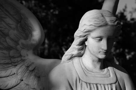 A black and white shot of a melancholy looking angelの写真素材
