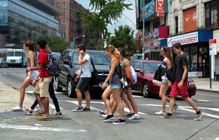 New York City, NY USA. Jul 2014. Teenagers on a busy New York city crosswalk on the way to school.