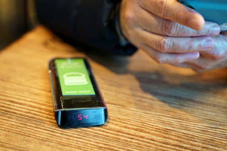 West Hartford, CT USA. Dec 2018. Surfing hands of a restaurant customer waiting for the electronic...
