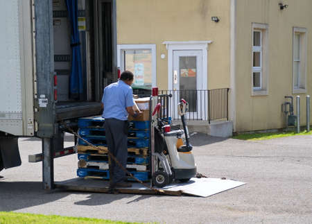 Cromwell, CT USA. May 2019. An African American man unloading supplies to fast food places with his...