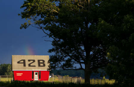 East Haddam, CT USA. Jun 2012. Goodspeed Airport building among a rainbow popping out of a dark blue...