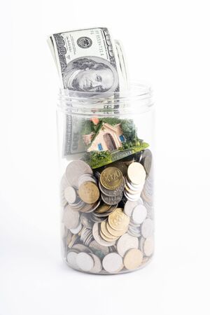 Miniature house with coins in jarの写真素材