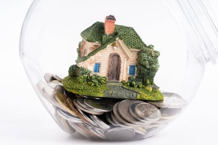 Miniature house with coins in jarの写真素材