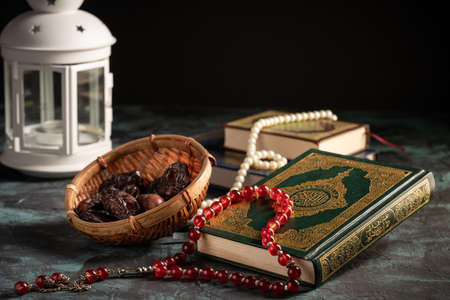 Islamic concept for eid and ramadan: The holy qoran with tasbih (rosary beads) and datesの写真素材