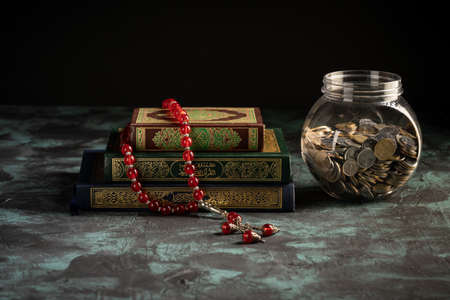 Zakat concept: Jars fulls with coins and money with the holy qoran. copy space for textの写真素材