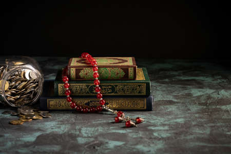 Zakat concept: Jars fulls with coins and money with the holy qoran. copy space for textの写真素材