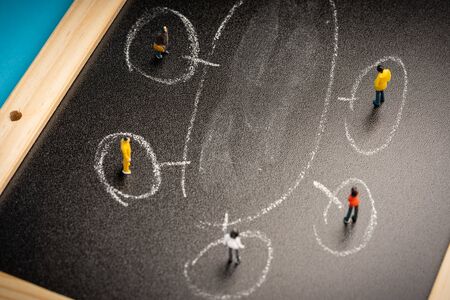business concept: a group of miniatures person on a chalkboard with copy space for textの写真素材