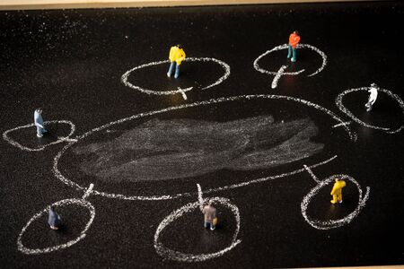 business concept: a group of miniatures person on a chalkboard with copy space for text