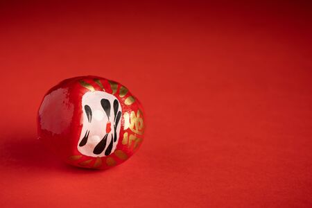 Daruma doll on red background, japanese dollの写真素材