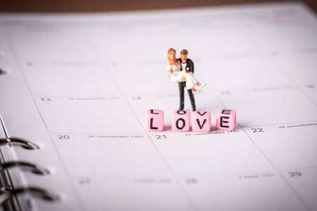 Love concept. Miniature couple against pink backgroundの写真素材