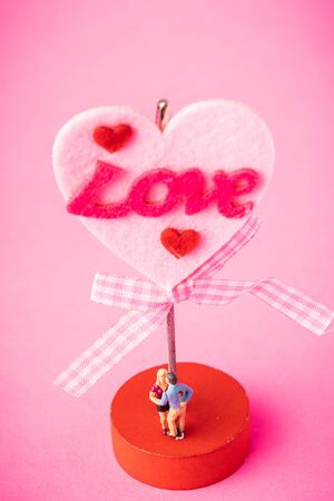 Love concept. Miniature couple against pink backgroundの写真素材