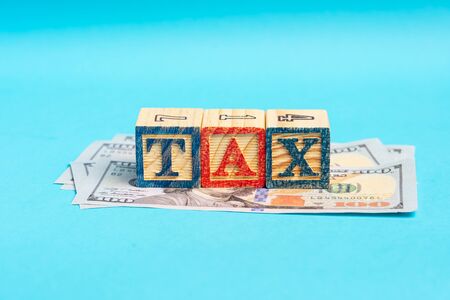TAX wordings on woodens blocks with US Dollar billsの写真素材