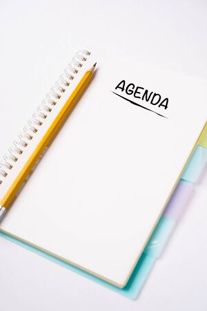 AGENDA wordings on a notebook on a table, flat lay composition, copy space for textの写真素材