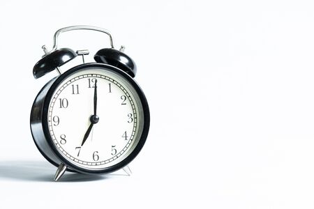 A black alarm clock isolated against white backgroundの写真素材