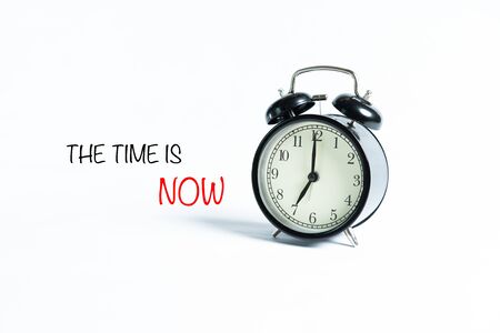 âTHE TIME IS NOWâ wordings with alarm clock against white backgroundの写真素材