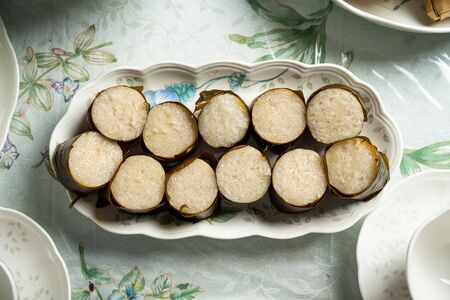 Glutinous rice is wrapped with lerek or banana leaf encased in bamboo culm and cooked in open fire / Lemang / A must have in every traditional Malay household, eaten with beef or chicken rendangの写真素材