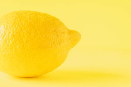 Lemon isolated on yellow backgroundの写真素材