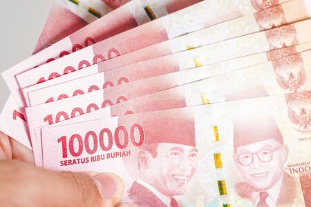 Indonesian rupiah currency notes in one hundred thousand denomination isolated against white backgroundの写真素材