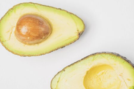An avocado cut into half on white backgroundの写真素材