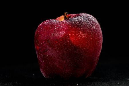 fresh and delicious red apple isolated against black background, with water droplets on the apple, selective focusの写真素材