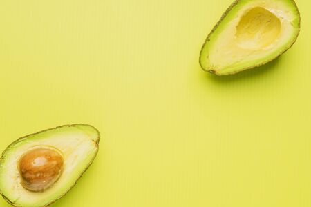 An avocado cut into half with green backgroundの写真素材