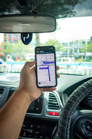 A man holding the iPhone X with Waze navigation app inside the car. Waze has gain popularity for its good navigation.のeditorial素材
