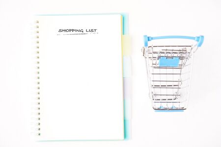 âShopping Listâ wordings on a notebook with a miniature trolley. Copy space for textの写真素材