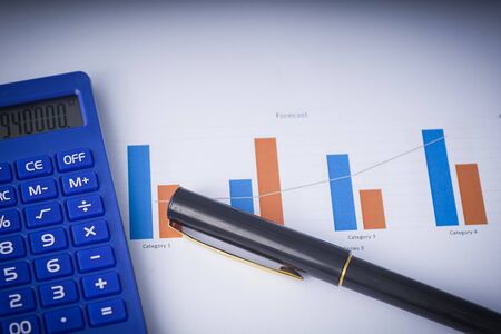 Business and Finance concept: flat lay composition of a work desk with papers, pen and calculators