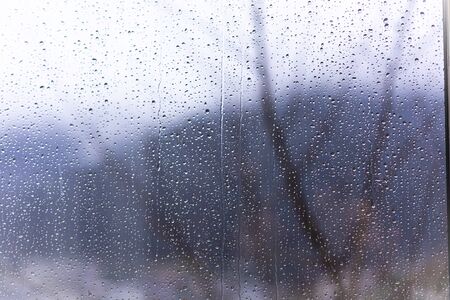 Raindrops on window glass with blur backgroundの写真素材