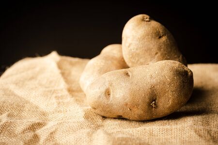 Fresh Potatoes on a rag with dark backgroundの写真素材