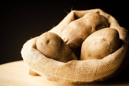 Fresh Potatoes on a rag with dark backgroundの写真素材