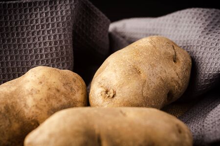 Fresh Potatoes on a rag with dark backgroundの写真素材