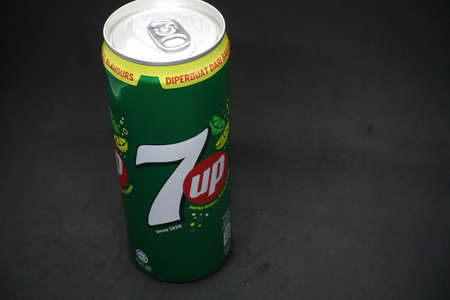 A 7up can against isolated black background, a tasty fruits flavour carbonated drink