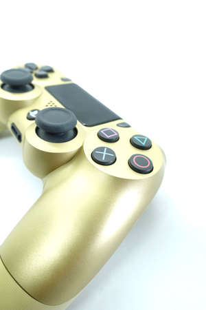 A gold colour Playstation 4 DS4 controller against isolated white background