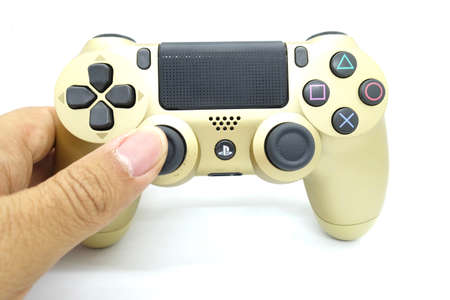 A gold colour Playstation 4 DS4 controller against isolated white background