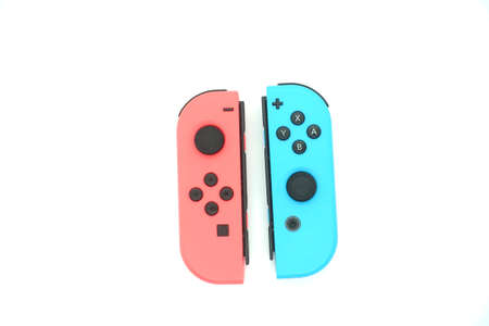A neon blue and neon red Nintendo Switch joycon against isolated white background