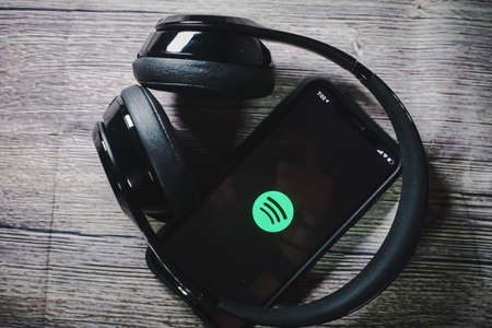 An iphone 11 screen showing spotify icon with beats earphone, perfect for listening musics on the goのeditorial素材