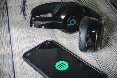An iphone 11 screen showing spotify icon with beats earphone, perfect for listening musics on the goのeditorial素材