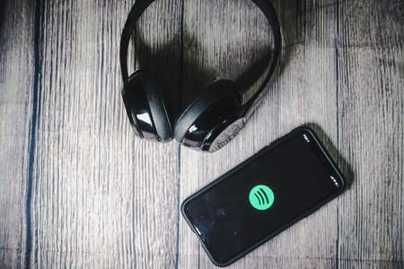 An iphone 11 screen showing spotify icon with beats earphone, perfect for listening musics on the goのeditorial素材