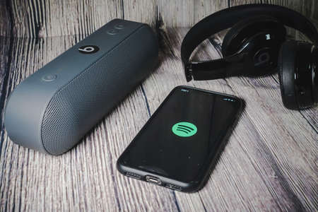 An iphone 11 screen showing spotify icon with beats earphone, perfect for listening musics on the goのeditorial素材