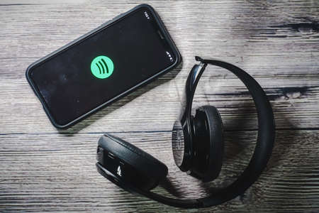 An iphone 11 screen showing spotify icon with beats earphone, perfect for listening musics on the goのeditorial素材