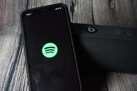 An iphone 11 screen showing spotify icon with beats pill speaker beside itのeditorial素材