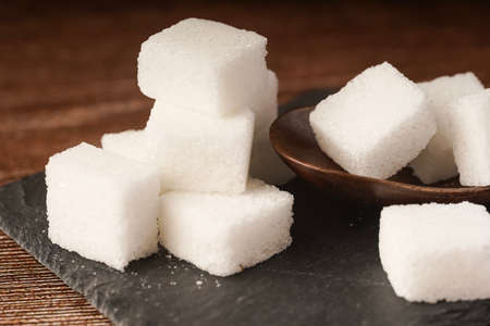 Sugar cubes with wooden spoon. Unhealthy eating conceptの写真素材