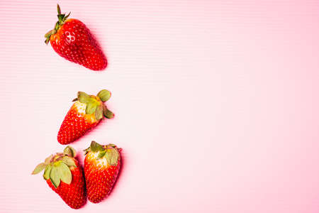 Flat lay composition of strawberries with pink background, top view, copy space for textの写真素材