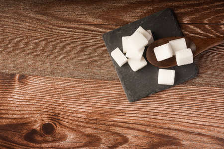 Sugar cubes with wooden spoon. Unhealthy eating conceptの写真素材