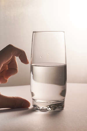 Glass half empty or glass half full. Psychology or motivational conceptの写真素材