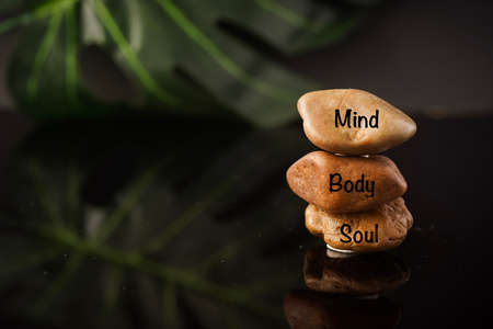 Zen Concept: Mind, Body and Soul wordings on stones against black background