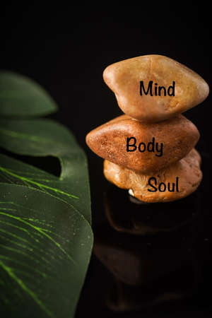 Zen Concept: Mind, Body and Soul wordings on stones against black background