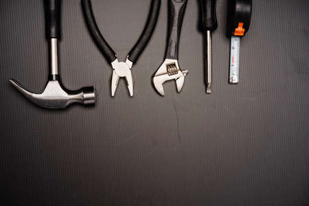 Flat lay composition of a set of tools, including hammer, pliers, wrench, screwdrivers and measuring...